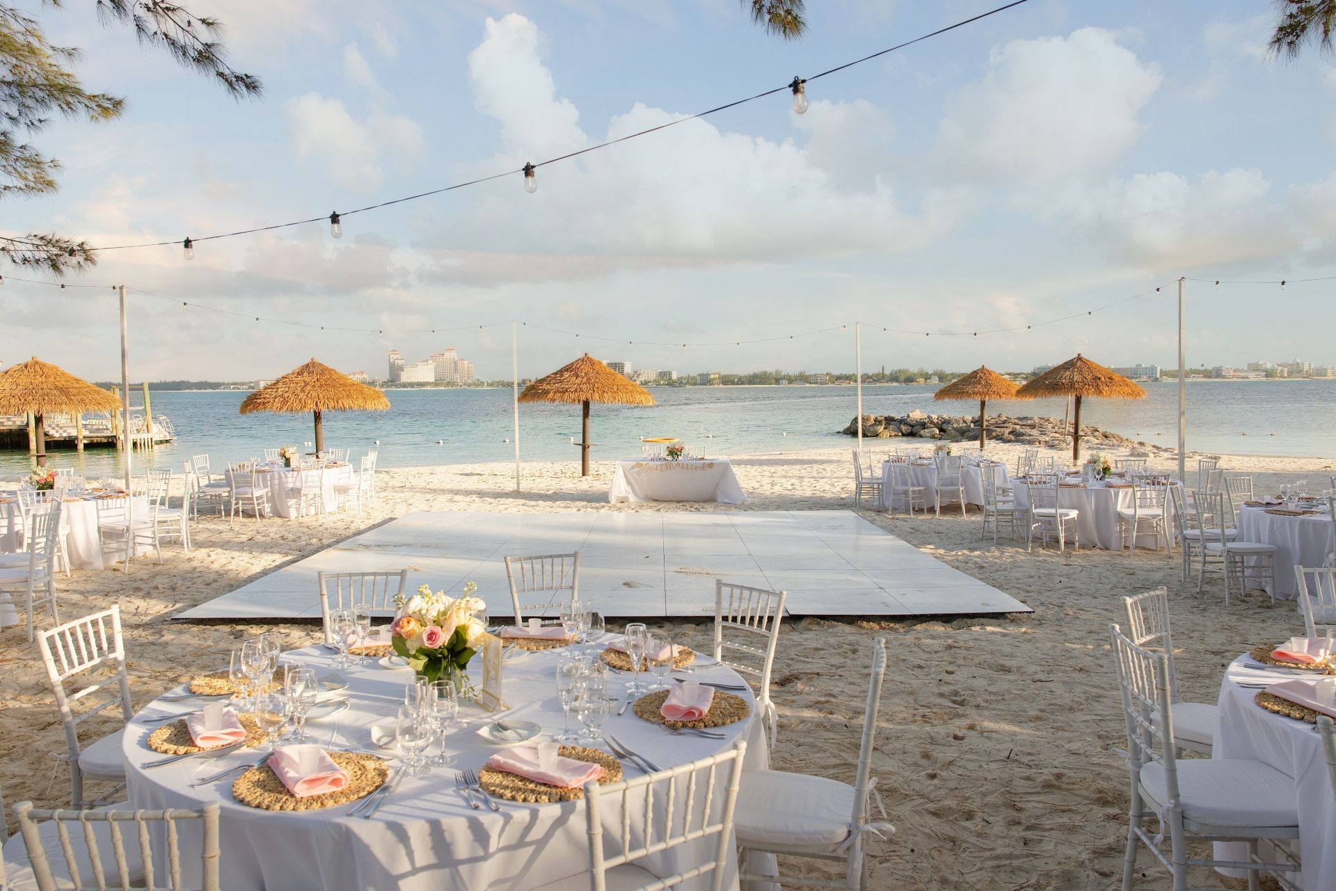 Beachfront wedding reception setup with fairy lights and ocean views in the Bahamas