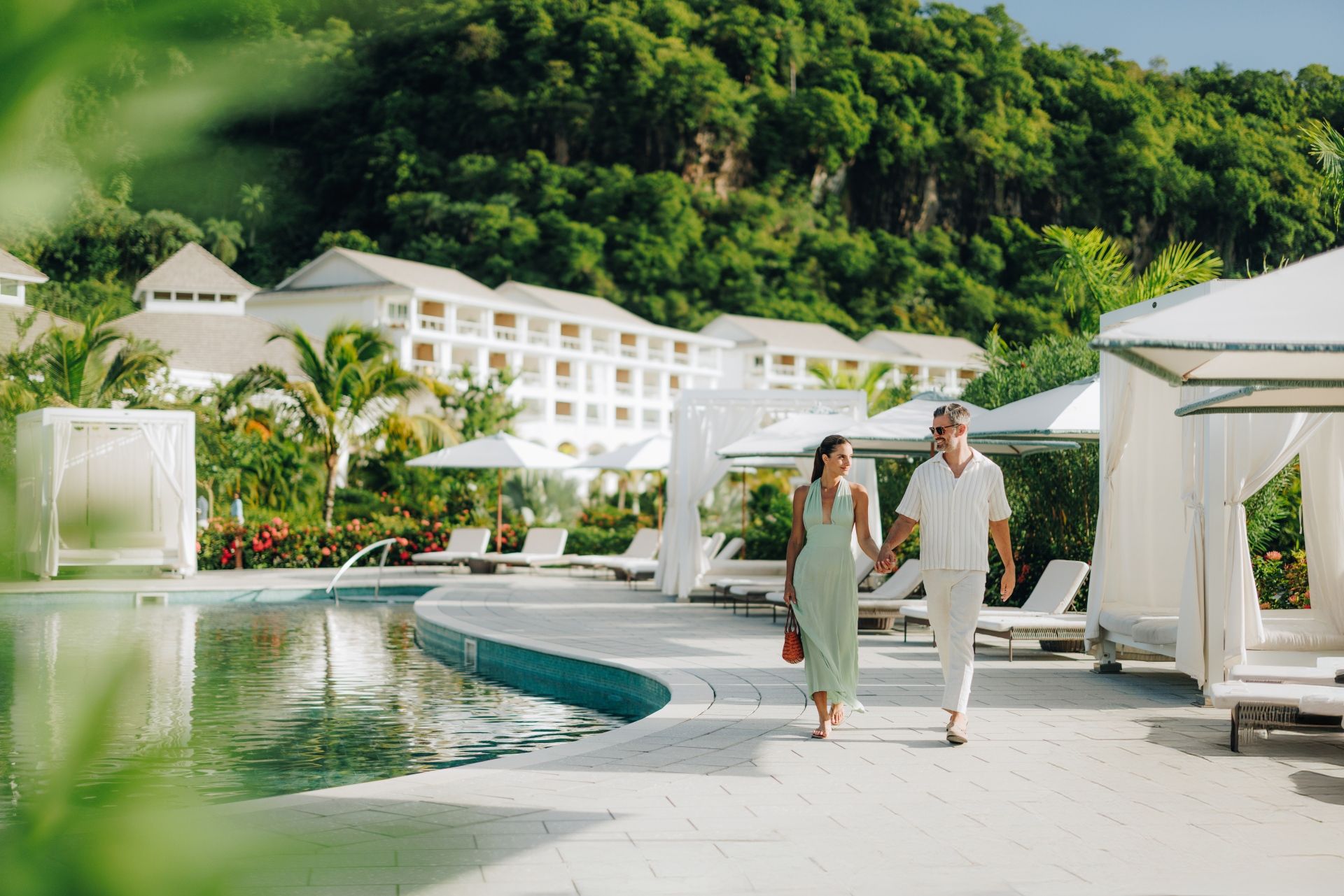 Couple walking together through lush Sandals resort grounds
