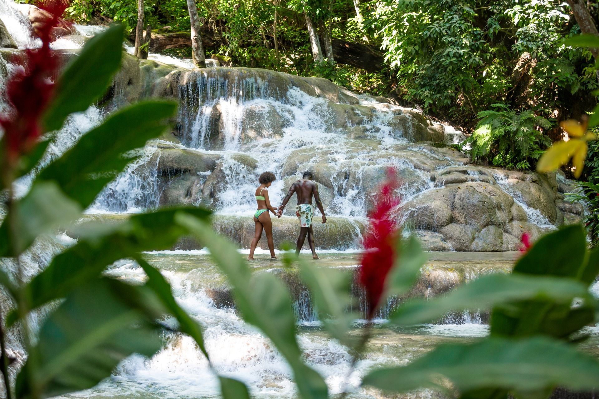 Couple holds hands while exploring Dunn's River Falls in Ocho Rios, Jamaica